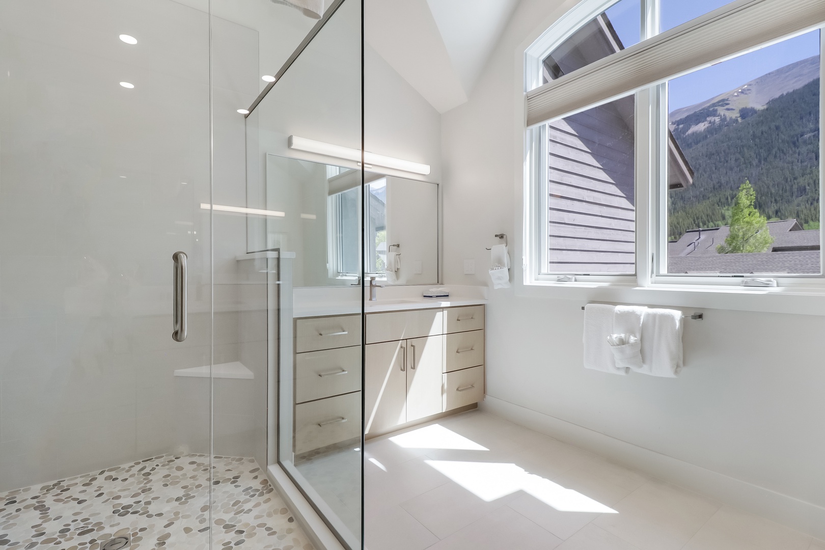 Freshen up in your bright, modern bathroom with a spacious walk-in shower and stunning mountain views. Clean lines, natural light, and plush towels make it easy to relax after a day of adventure.