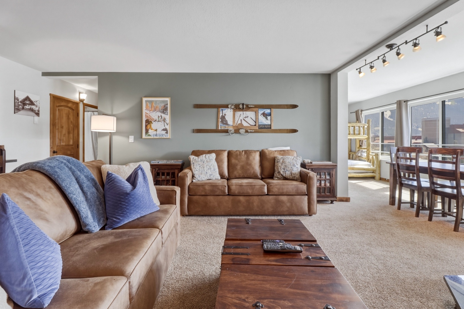 Settle into your spacious living room with plush leather sofas and warm wood accents, perfect for relaxing after mountain adventures.