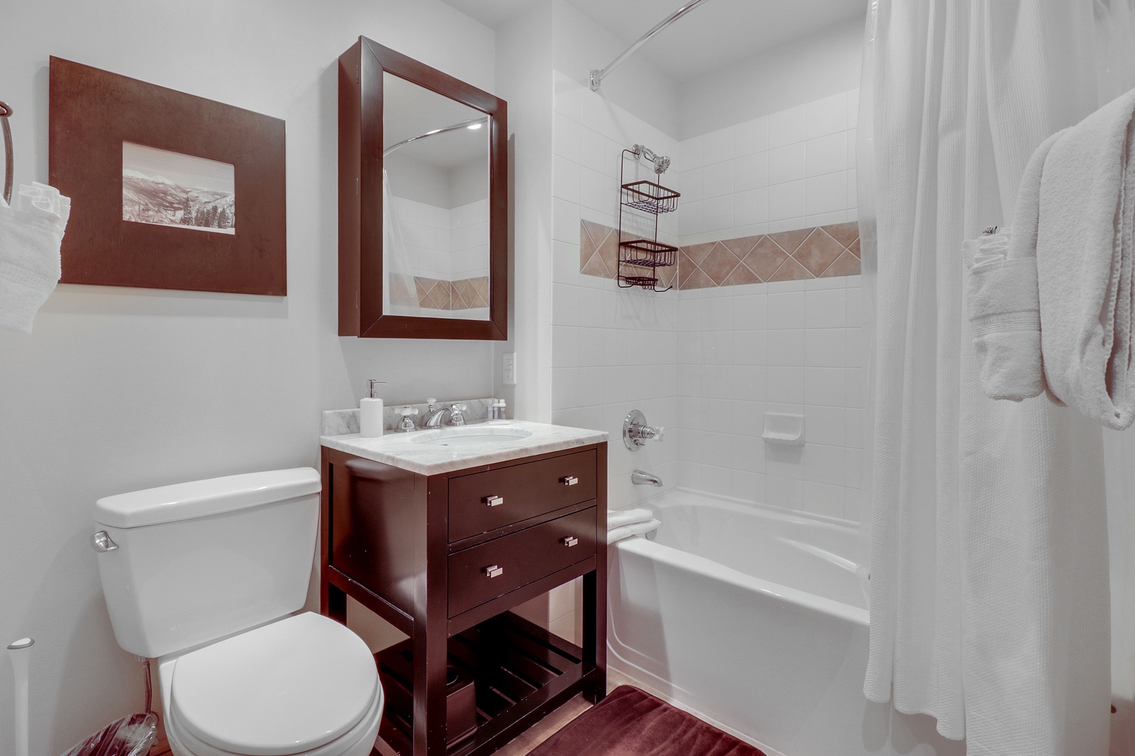 Your private bathroom features a full tub-shower combo, elegant tile accents, and plush towels ready for your arrival.