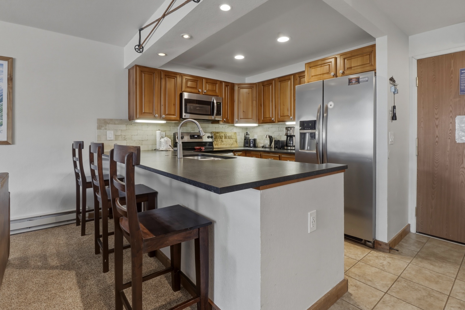Prepare meals together at your spacious kitchen island with modern appliances and warm wood cabinetry creating the perfect home base.