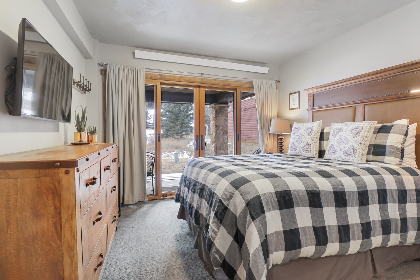 Wake up to mountain views from your cozy bedroom, where rustic wood furnishings and soft plaid bedding create the perfect alpine retreat for your restful nights.