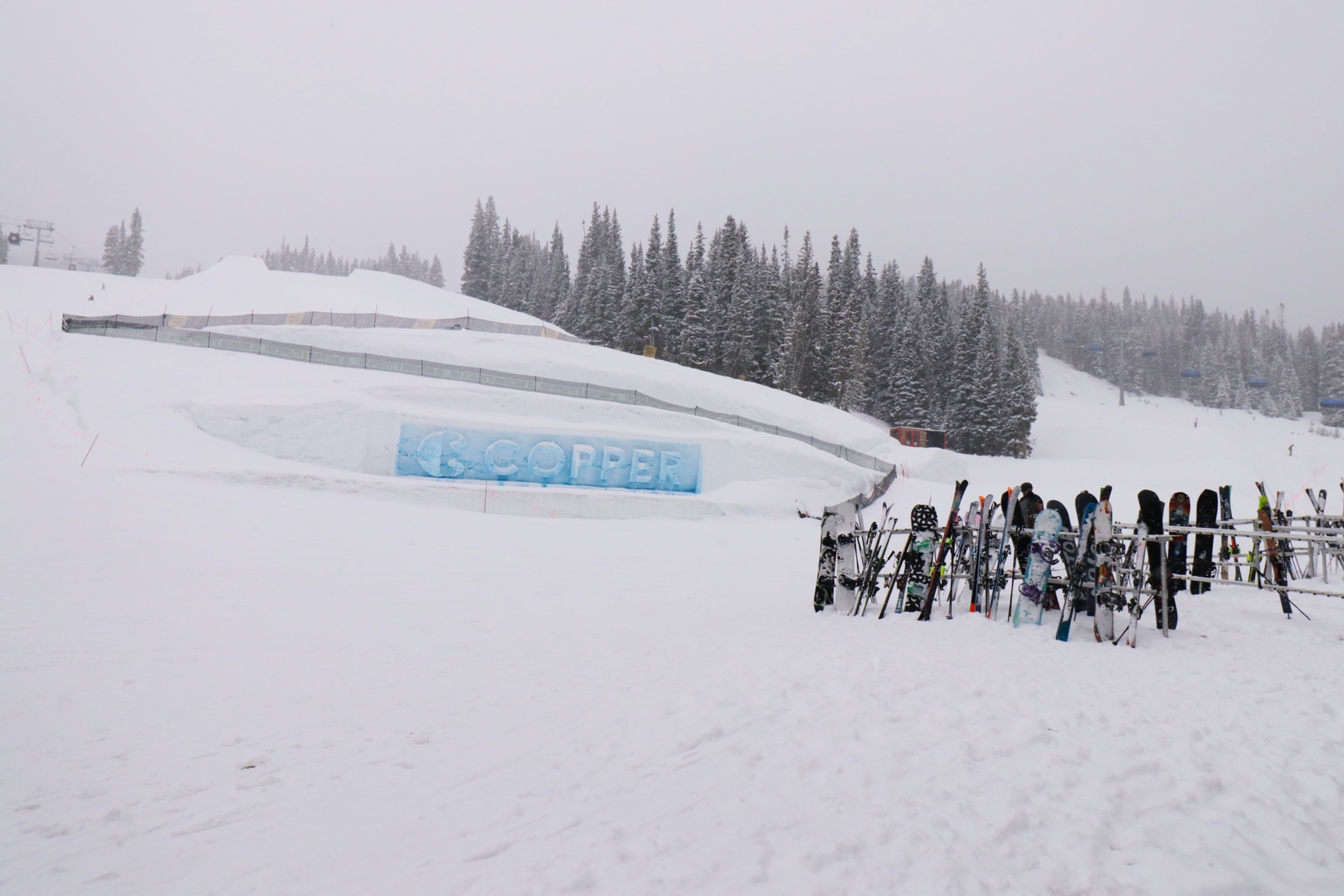 Ski resort property surrounded by snow-covered evergreen forests and well-maintained slopes, with easy ski equipment storage near the main building.