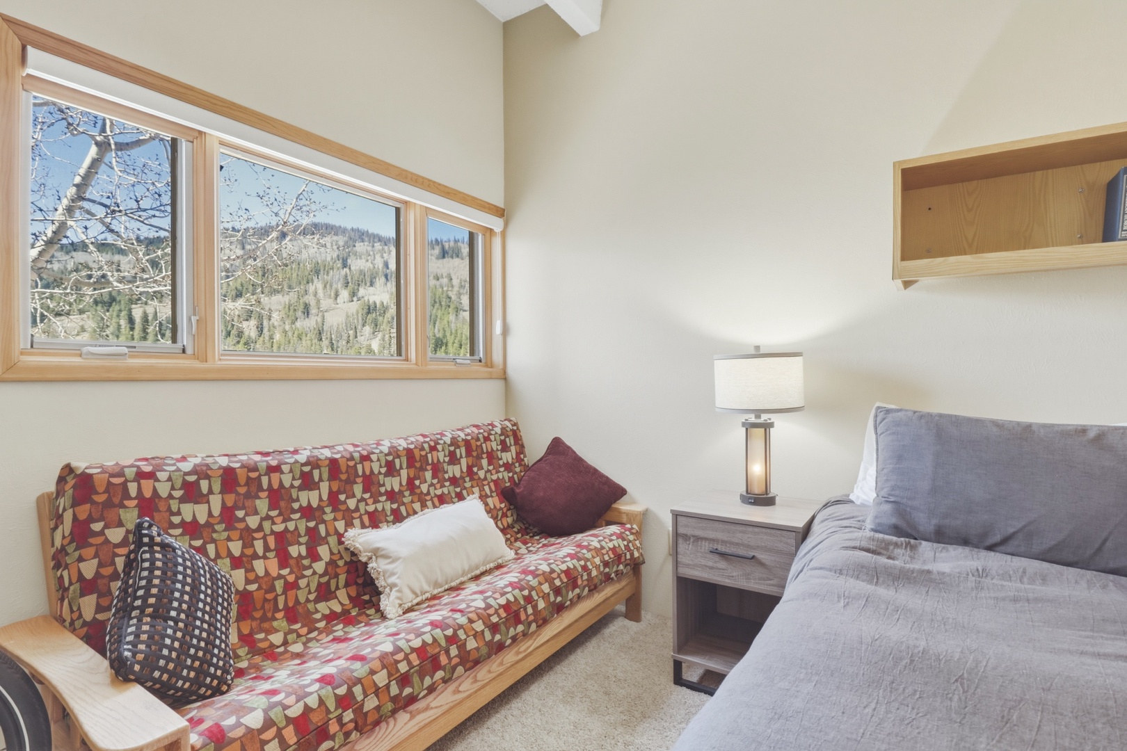 Wake up to breathtaking mountain views through your bedroom's expansive windows, where natural light fills your cozy retreat.