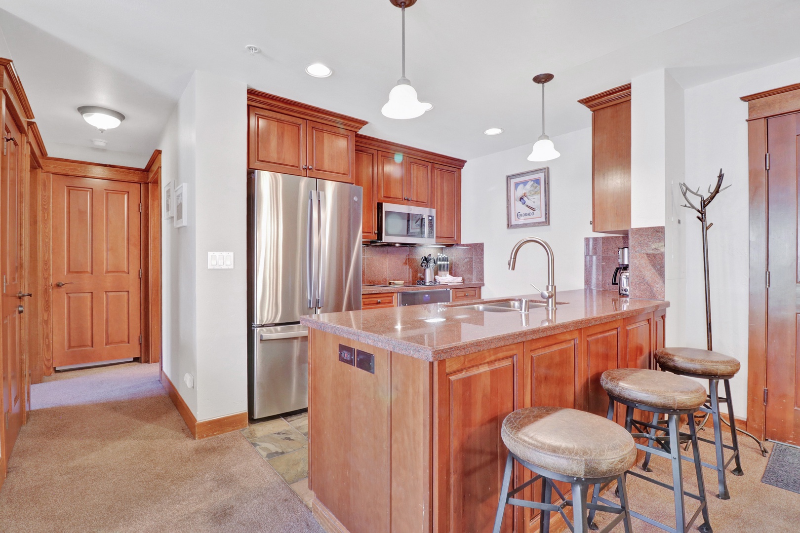 Your fully-equipped kitchen features granite counters, stainless appliances, and an inviting island with bar seating where you can gather for meals or morning coffee.
