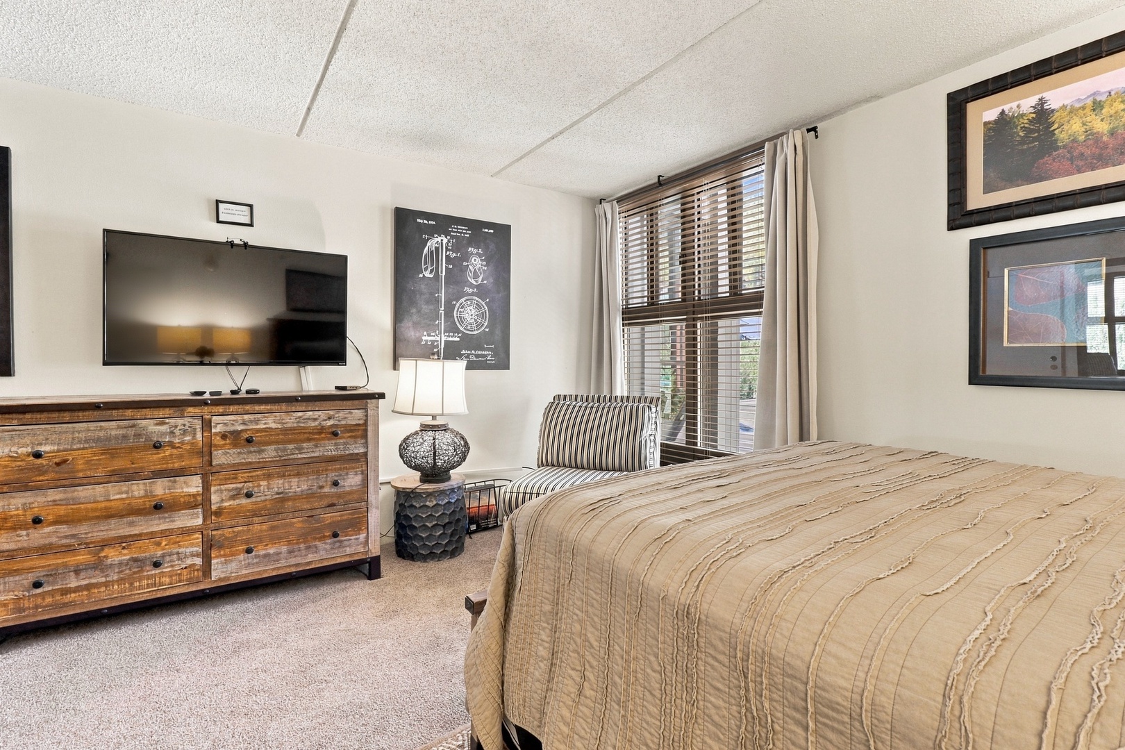 Unwind in your peaceful bedroom with a plush bed, cozy accent chair, and ample natural light streaming through the window. Perfect for restful nights after a day of adventure.