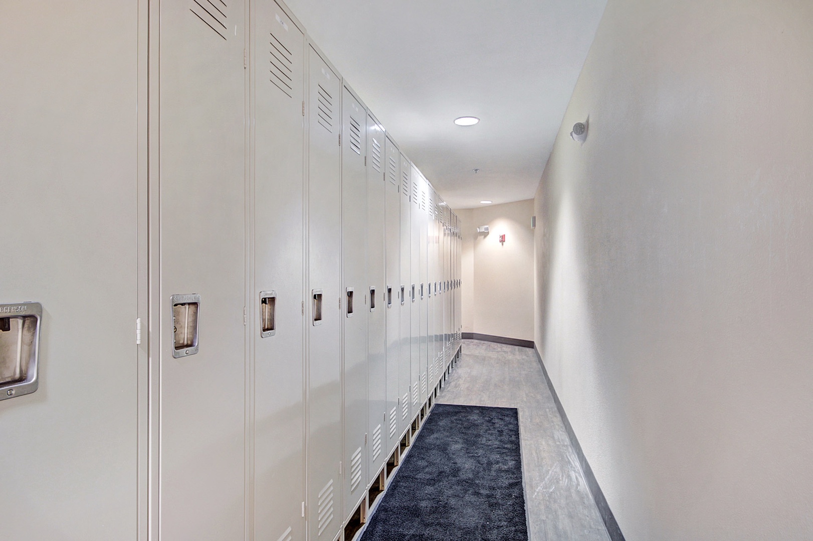 Clean, secure storage lockers line this hallway, giving you a dedicated space for your belongings during your stay. Bright lighting and fresh finishes create a welcoming, organized feel.
