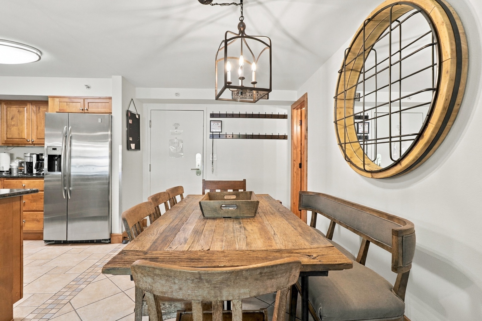 Gather around this handsome reclaimed wood dining table under the warm glow of vintage-style lighting. The adjoining kitchen makes meal prep a breeze for your group.