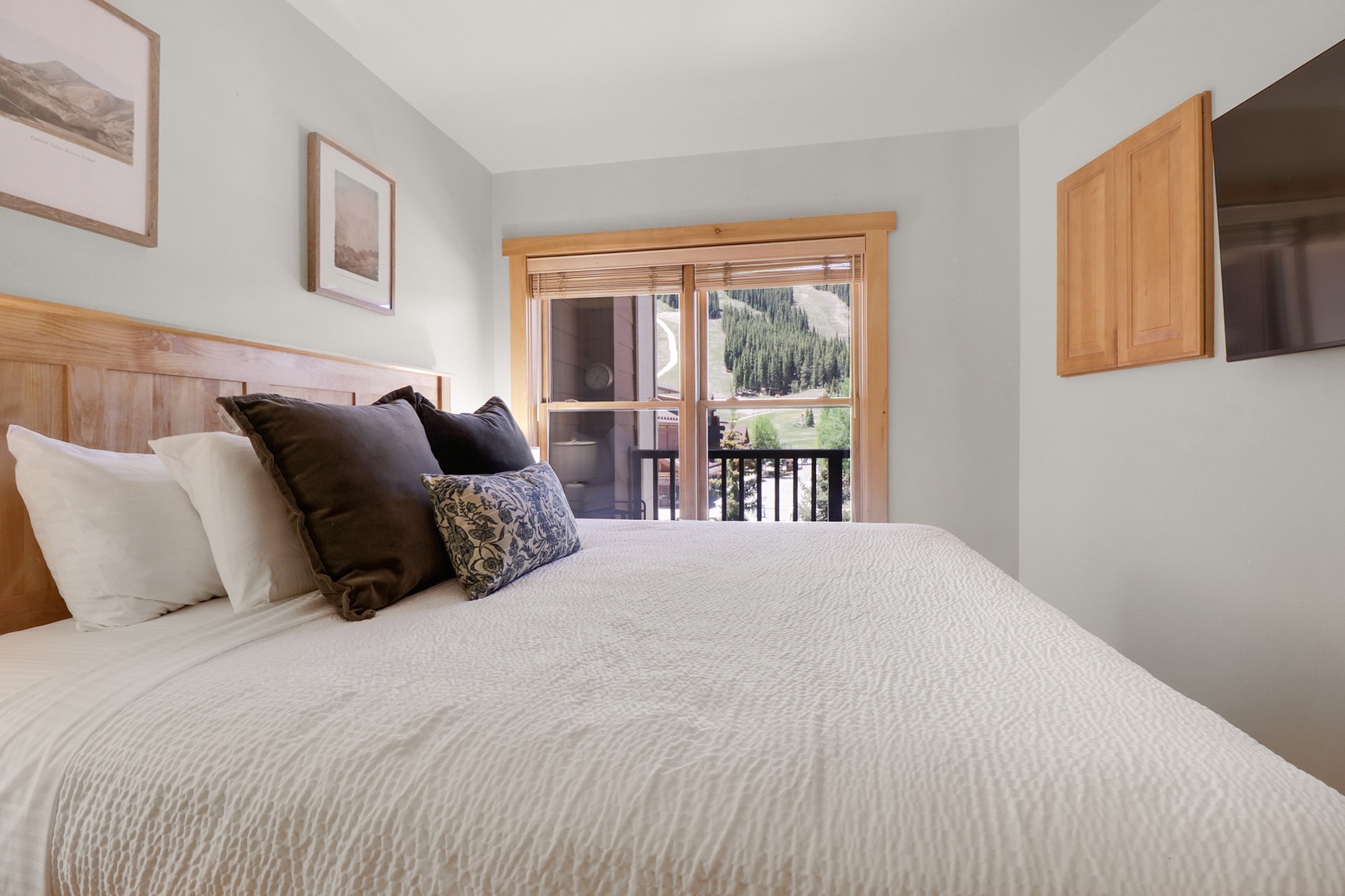Wake up to stunning mountain views framing your private balcony, where soft linens and warm wood tones create your peaceful alpine retreat.