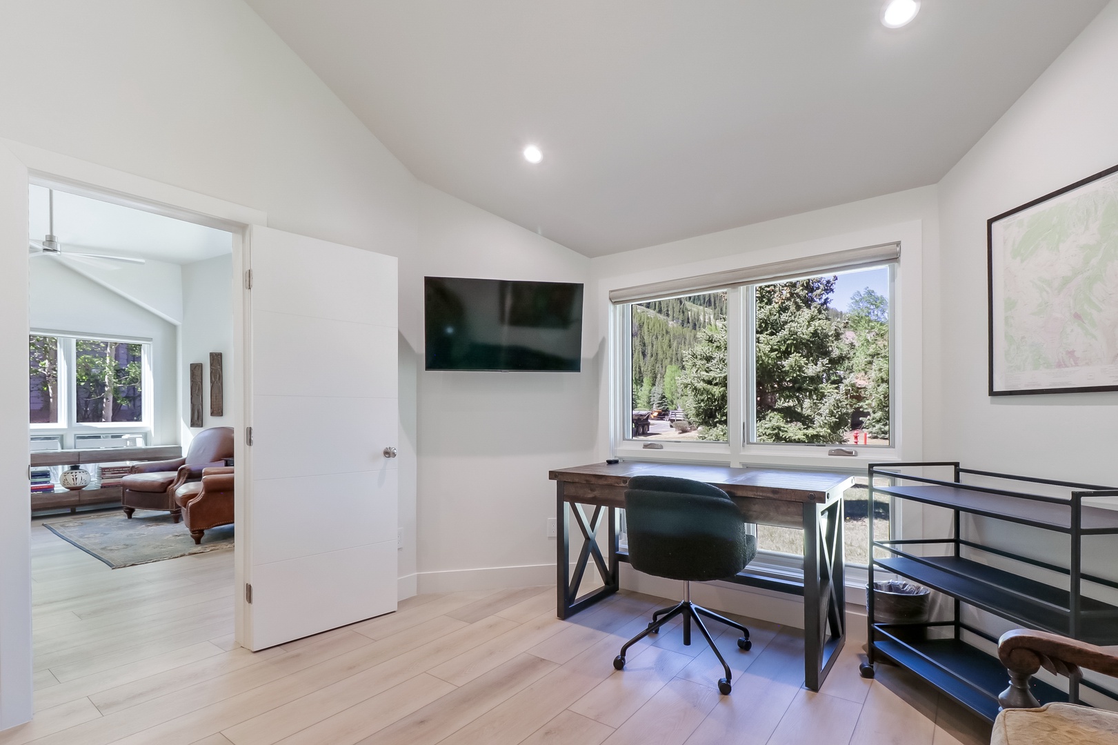 A bright workspace overlooks lush garden views, offering a peaceful spot to catch up on emails or simply enjoy your morning coffee.