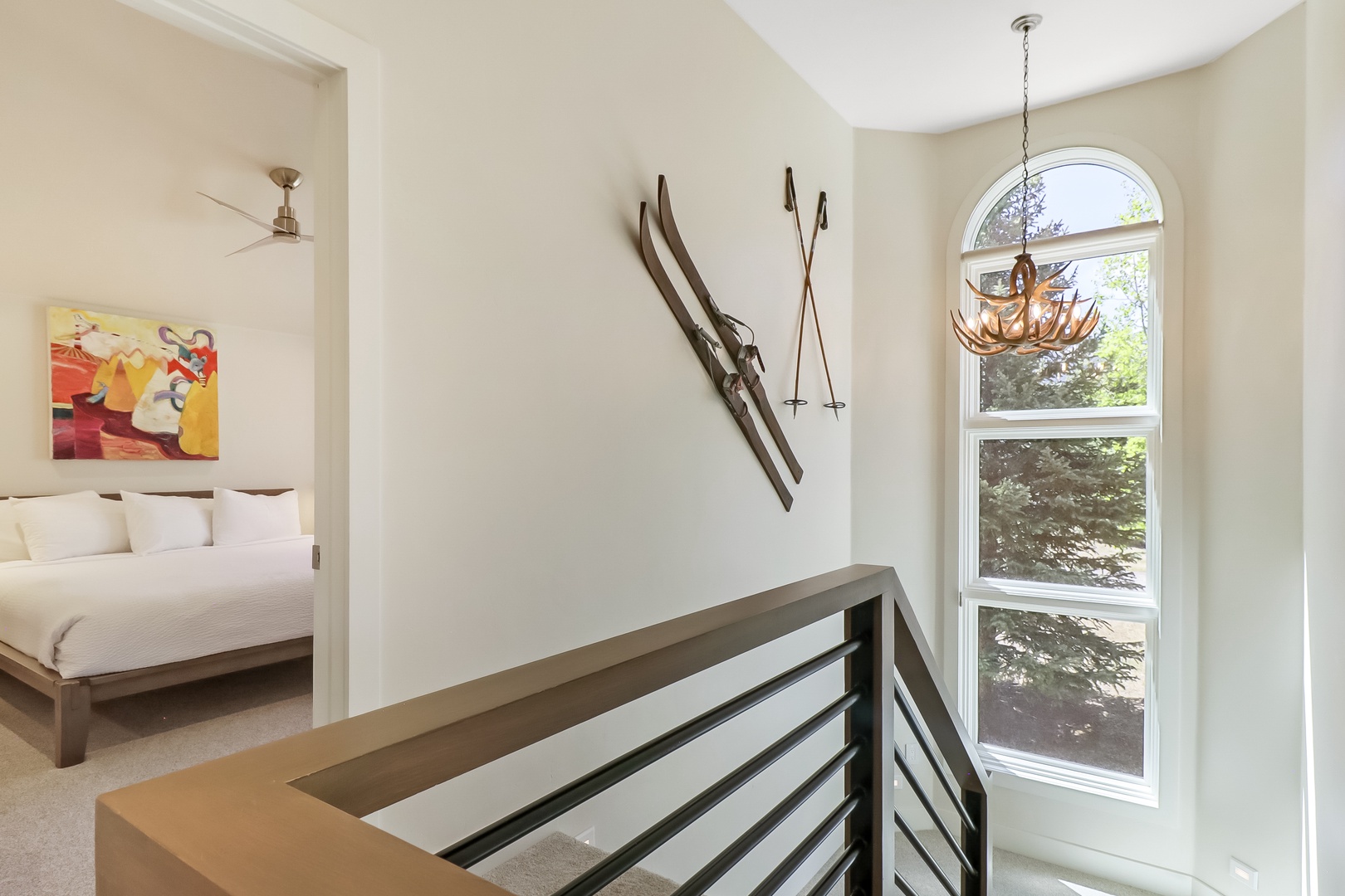 Natural light floods through the arched window, illuminating the mountain-inspired decor and inviting you to relax in this thoughtfully designed space with a view of the surrounding greenery.