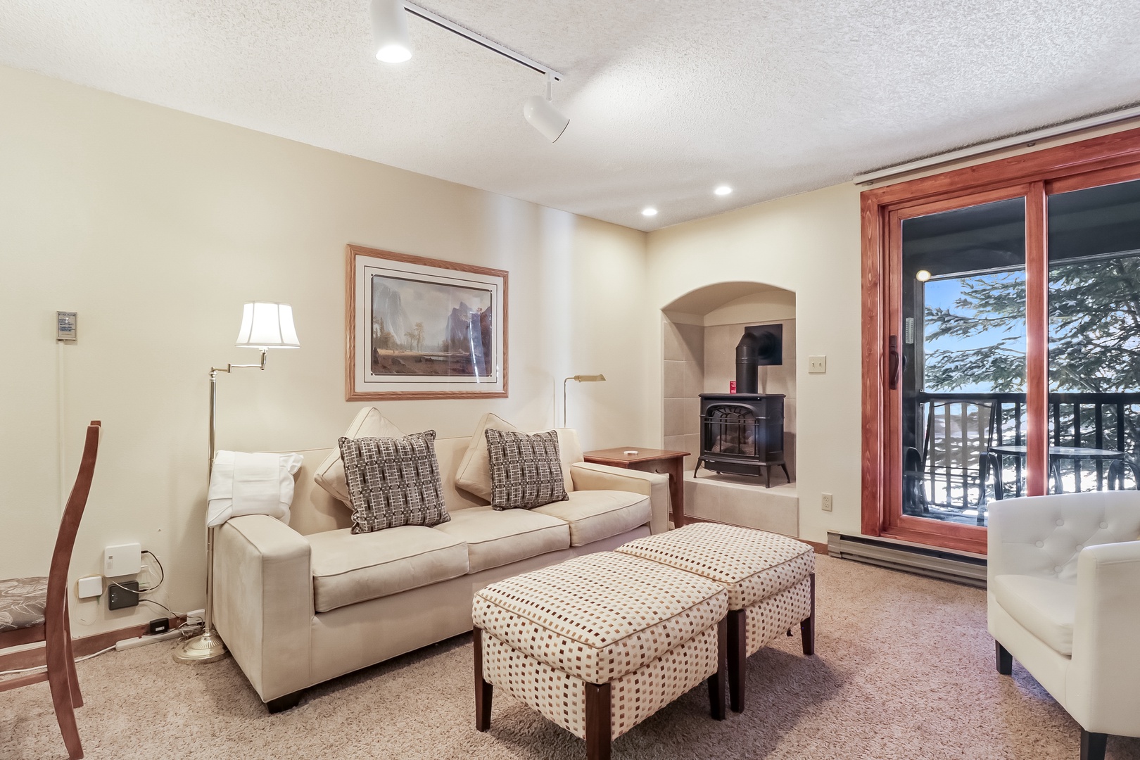 Sink into plush seating by your crackling fireplace, where snowy mountain views frame perfect winter evenings through expansive windows.