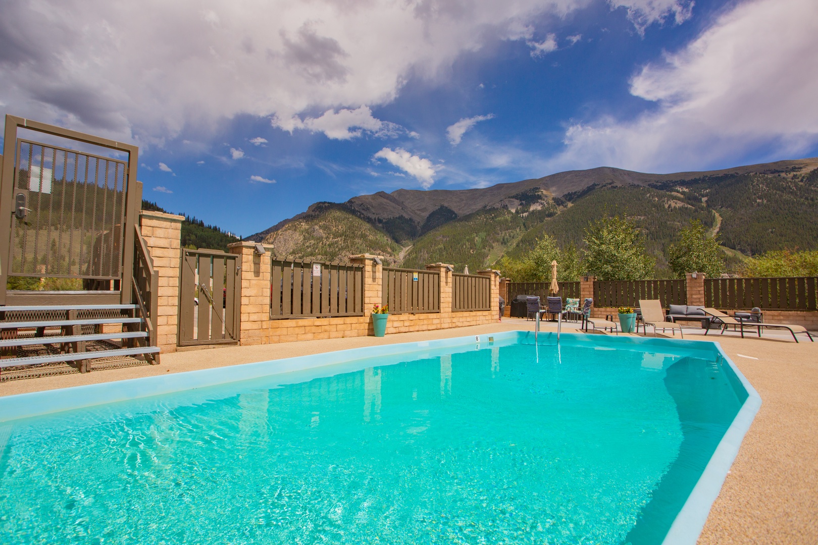 A stunning outdoor pool awaits you, framed by majestic mountain peaks. Lounge on the spacious deck and soak in the breathtaking alpine backdrop.