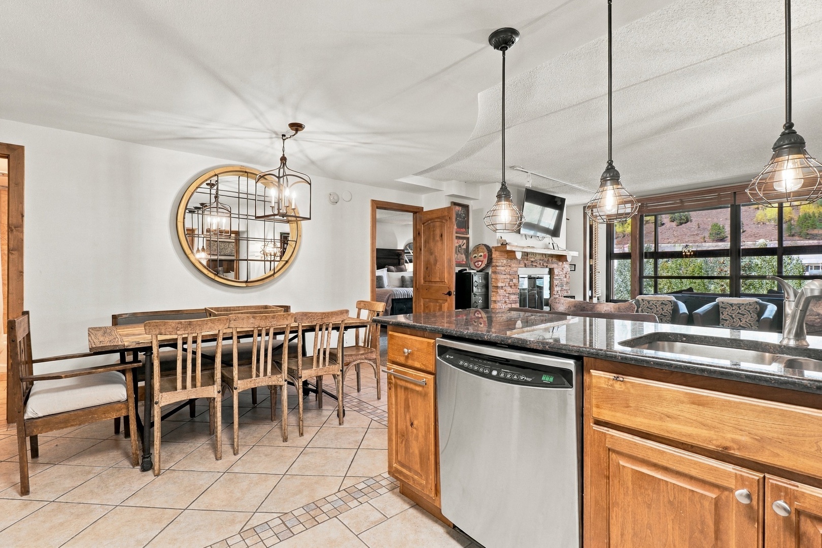 Gather around the spacious farmhouse dining table where rustic wood meets industrial charm. The fully equipped kitchen features granite counters and modern appliances with scenic red-rock views through expansive windows.