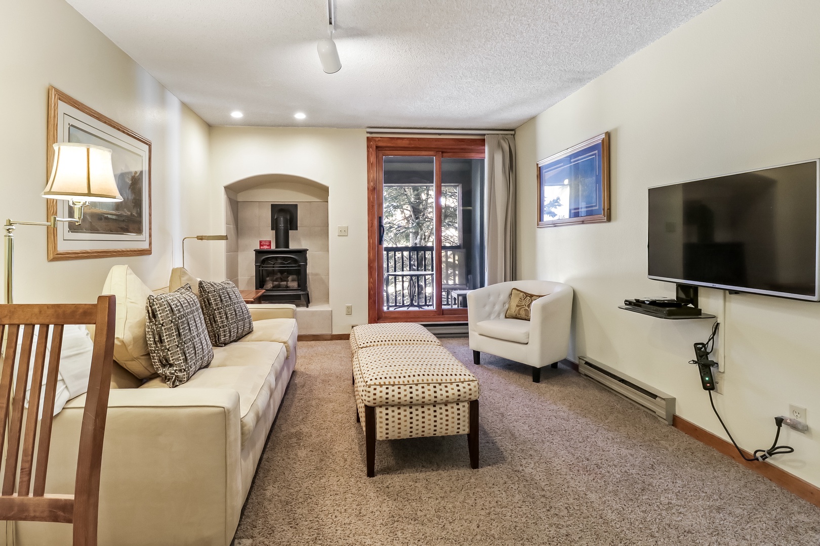 Unwind in your cozy living space with plush seating, fireplace warmth, and mountain views from your private balcony.