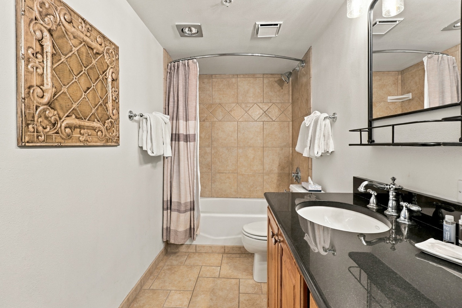 Refresh in your elegant bathroom with a deep tub-shower combo, polished countertops, and soft towels waiting for you. The tasteful decor adds a welcoming, refined touch to your daily routine.