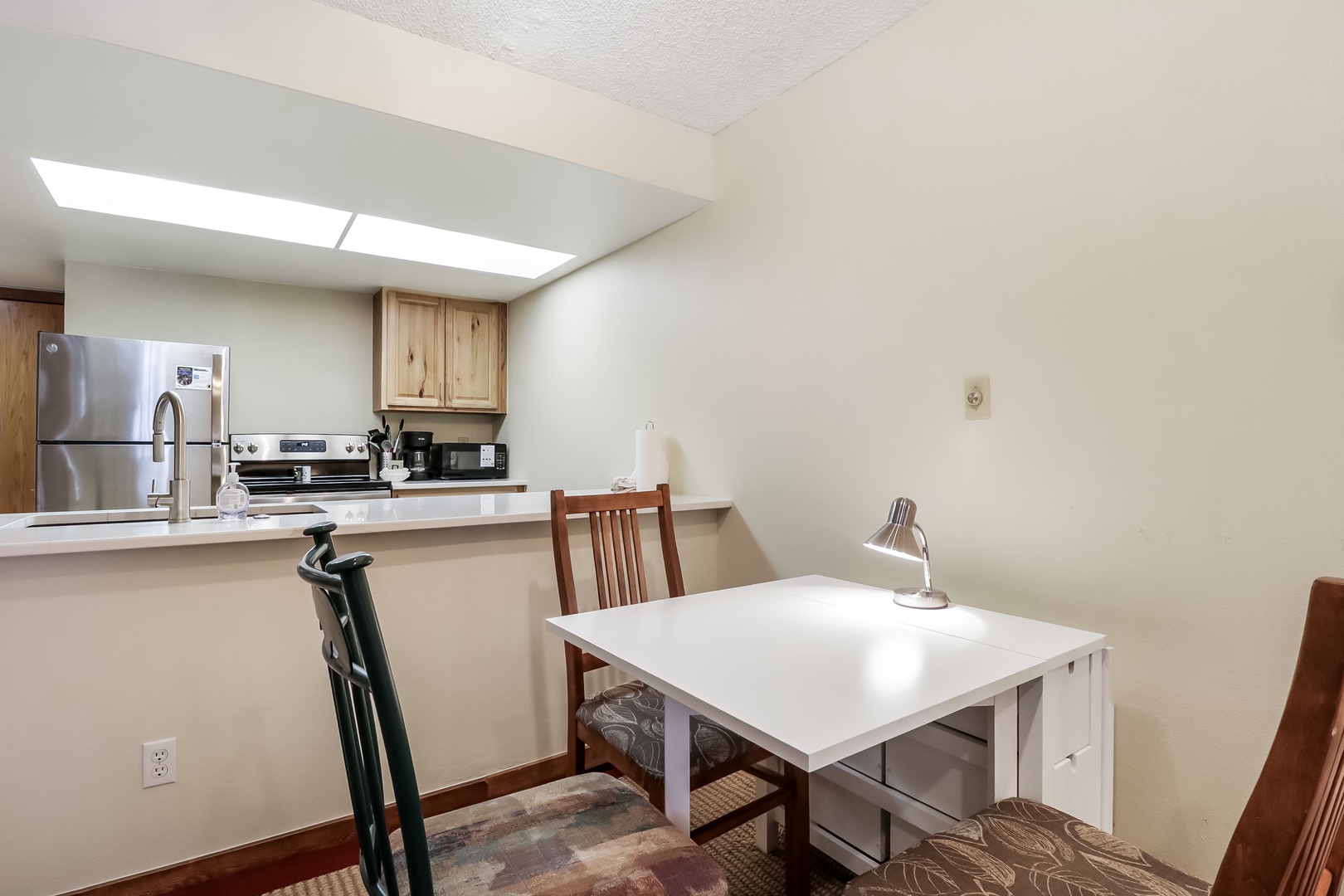 Your bright workspace features a clean desk under the skylight, perfect for catching up on work or planning adventures.