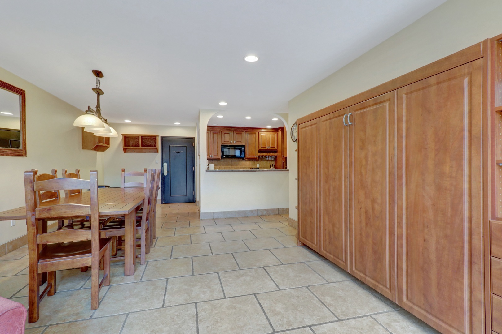 Spacious open layout featuring a dining area with seating for eight, a fully equipped kitchen, and a convenient Murphy bed for additional guests. Perfect for family gatherings and entertaining.