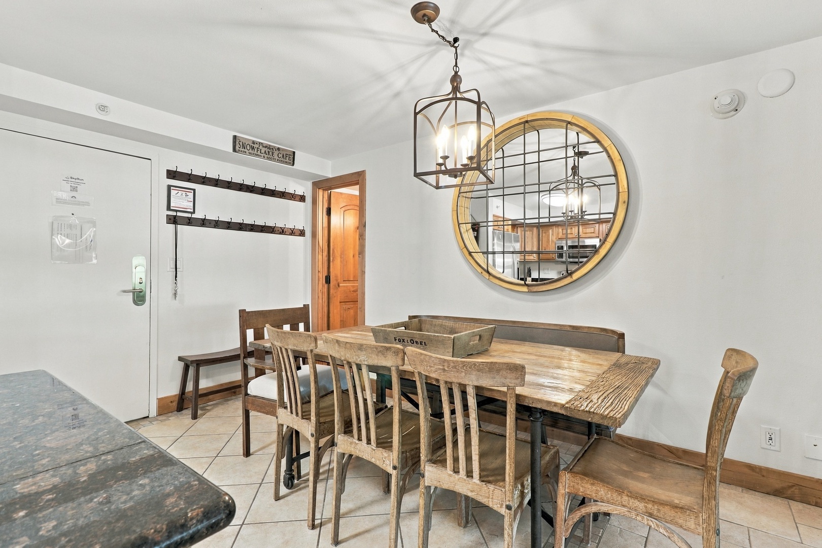 Gather around this handsome rustic farmhouse table, where you'll share meals under charming lantern lighting. The warm wood tones and circular mirror add character to your home-away-from-home dining space.