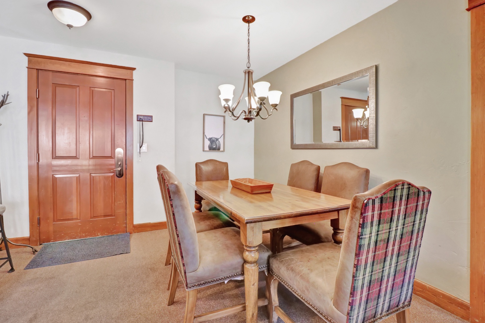 Gather around this warm dining table for meals and conversation. The rustic wood furnishings and welcoming chandelier create a cozy spot where you'll enjoy sharing stories over breakfast or planning your day's adventures together.