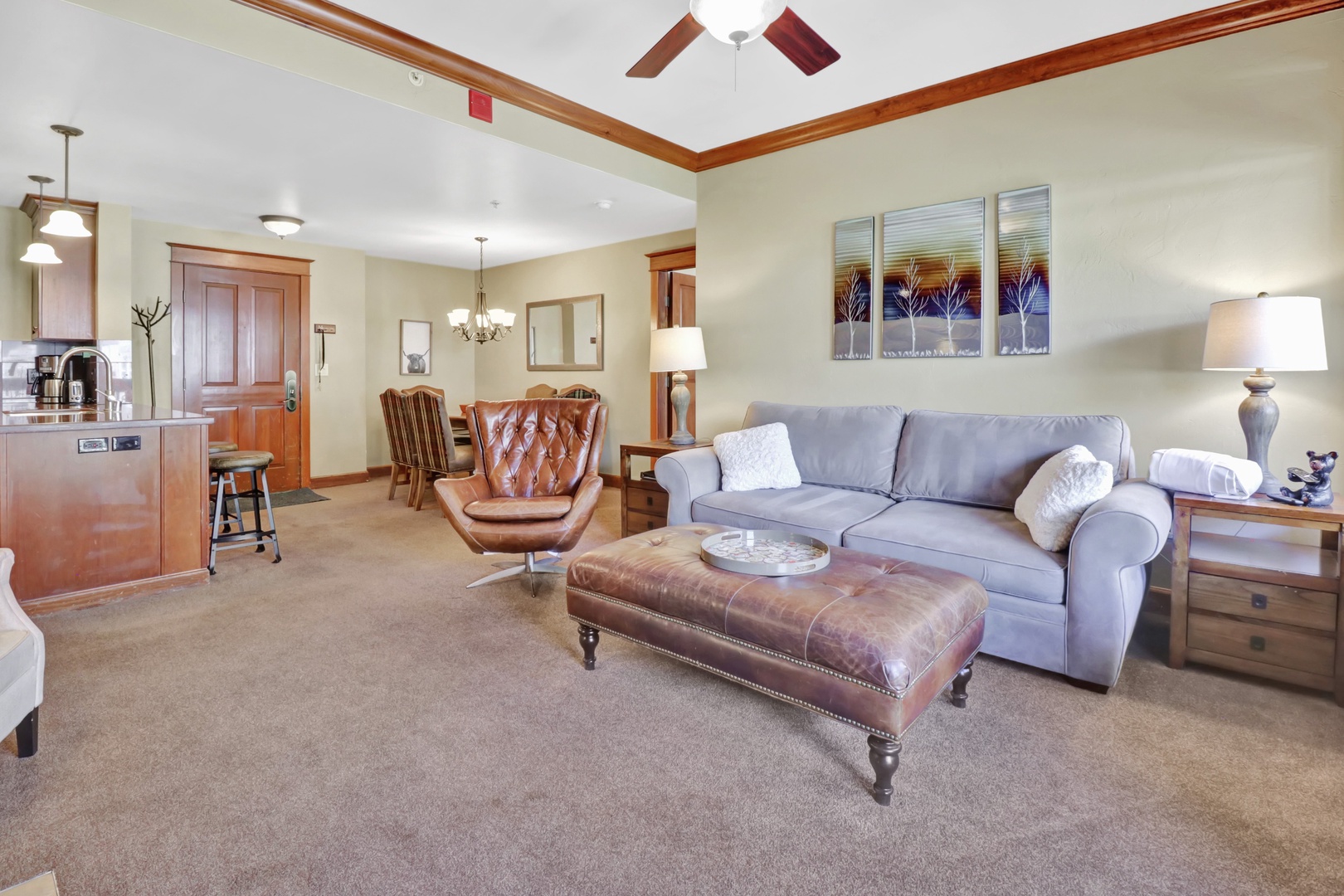 Unwind in your welcoming living space, where a plush sofa and leather accents invite you to relax after a day of adventure. Warm wood trim and a ceiling fan complete the comfortable, home-away-from-home feel.