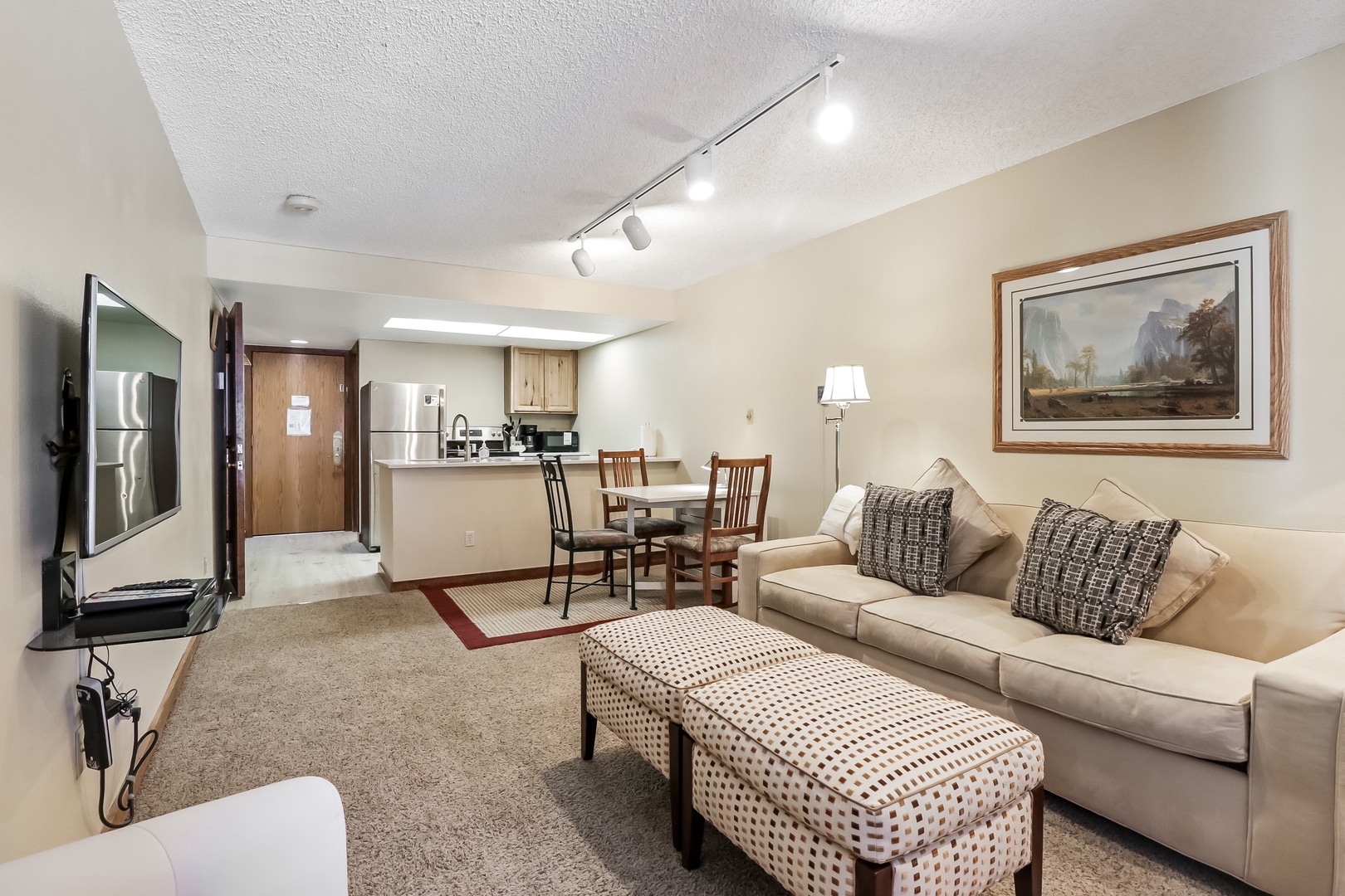 Relax in your spacious suite with plush seating, modern kitchen, and warm lighting creating the perfect home-away-from-home atmosphere.