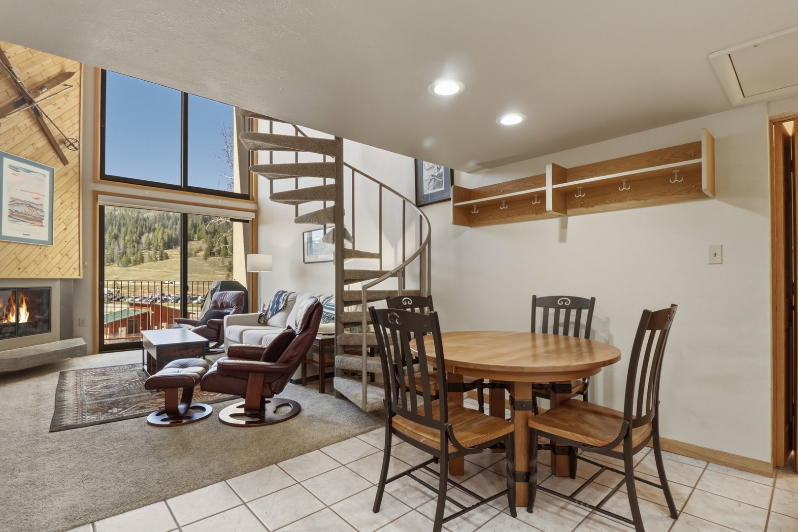Relax in your cozy living space with mountain views, spiral stairs to loft, and warm fireplace for perfect alpine evenings.