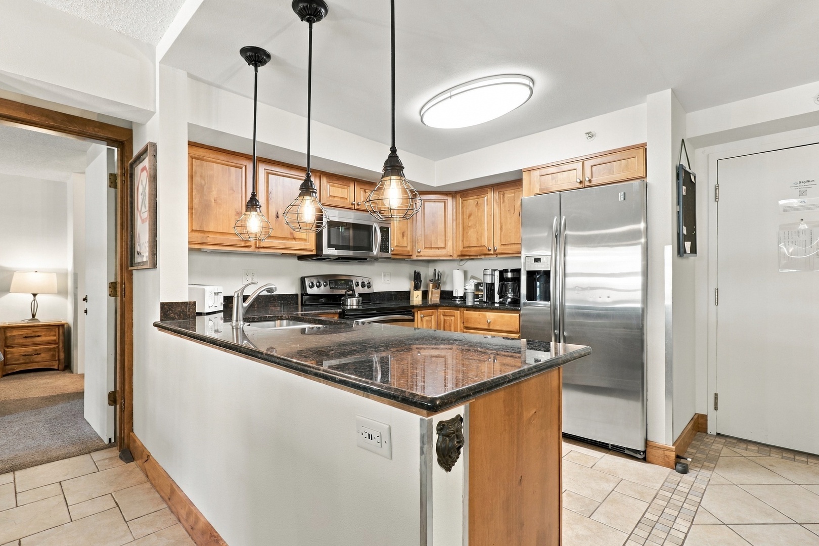 Your fully equipped kitchen features modern stainless steel appliances, gleaming granite countertops, and a spacious island perfect for meal prep or casual dining together.