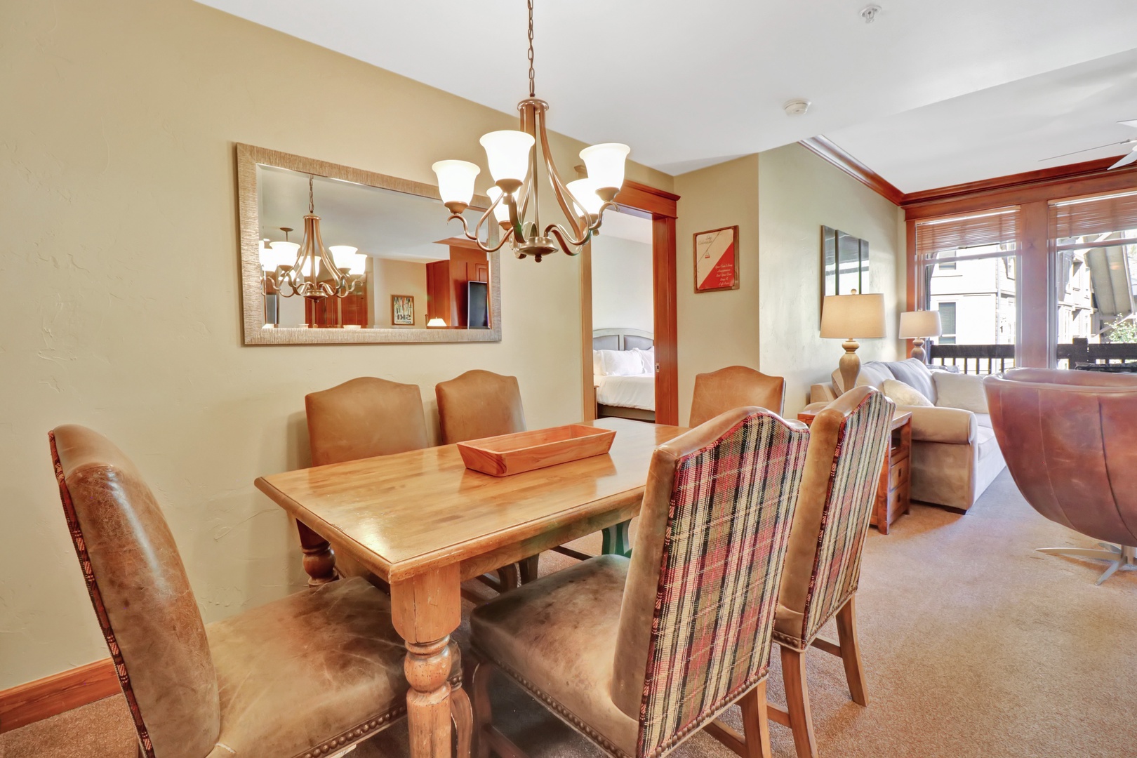 Gather around the inviting dining table for meals and memories, with rich wood finishes and warm lighting creating an intimate atmosphere. The open layout flows seamlessly into your cozy living space, perfect for easy conversation and relaxation.