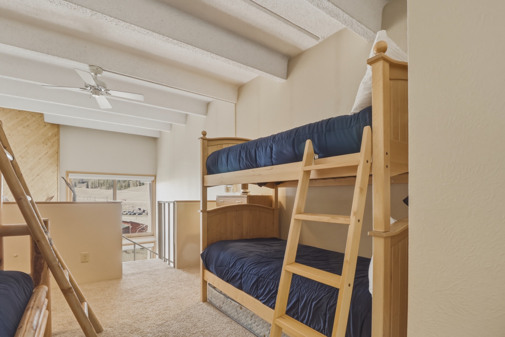 Rest comfortably in your cozy bunk bed room with exposed beam ceilings and natural light streaming through large windows.