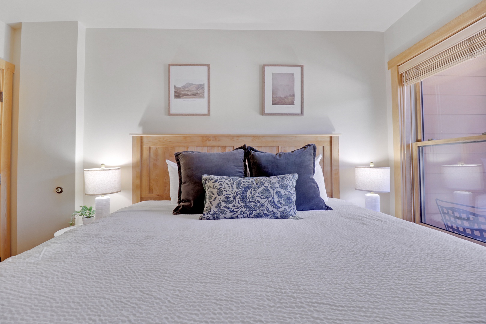Sink into crisp linens and plush pillows after your day exploring. This serene bedroom offers peaceful mountain art and warm lighting for your restful retreat.
