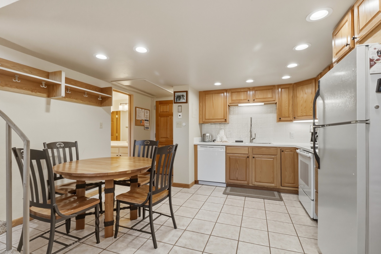Your fully-equipped kitchen awaits with warm wood cabinets, modern appliances, and a cozy dining nook where you can enjoy home-cooked meals together.