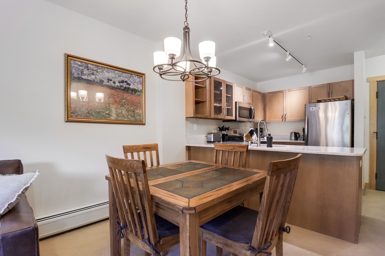 Gather around the dining table in your open-concept space, where warm wood tones and modern conveniences create the perfect setting for memorable meals and morning coffee together.