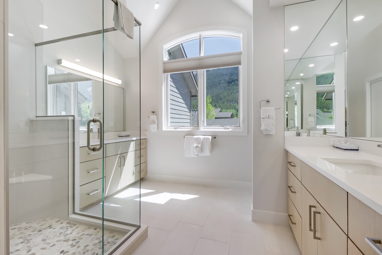Sunlight pours through arched windows into your spa-like bathroom, where sleek glass-enclosed shower and marble vanity await. Mountain views frame your daily refresh with natural beauty.