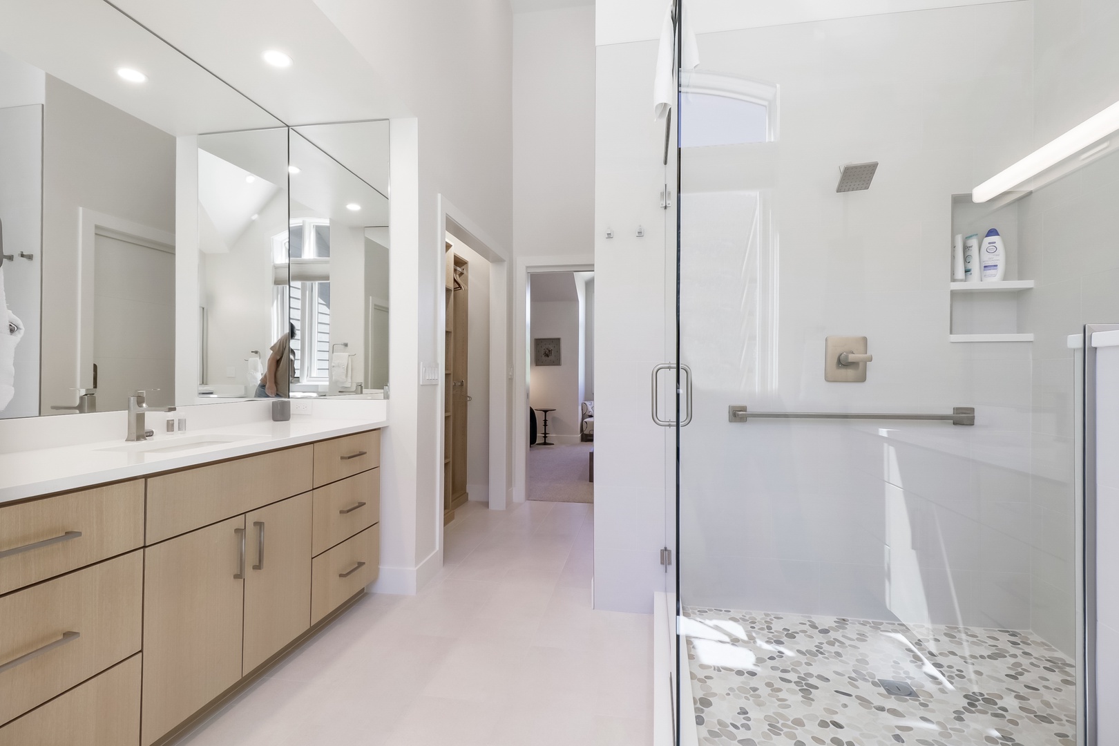 Step into your private spa-like ensuite, where bright natural light and clean modern finishes welcome you. Enjoy your spacious walk-in shower with stylish pebble flooring after a day exploring the area.