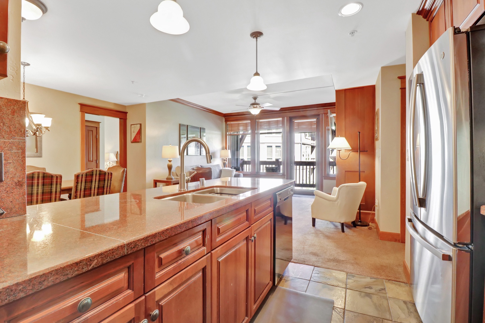 Step into your inviting open-plan retreat, where warm wood tones and granite counters meet plush seating. Prepare meals in your full kitchen, then relax by the windows with soft natural light spilling in.