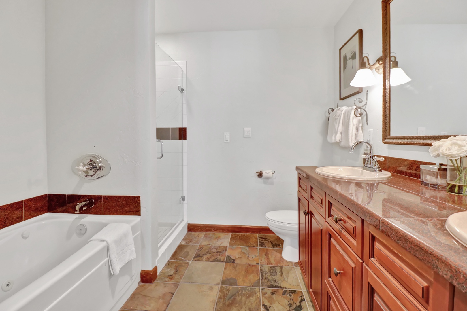 Unwind in your spacious bathroom with a deep soaking tub, rich marble counters, and warm wood cabinetry—your private retreat after a day of adventure.