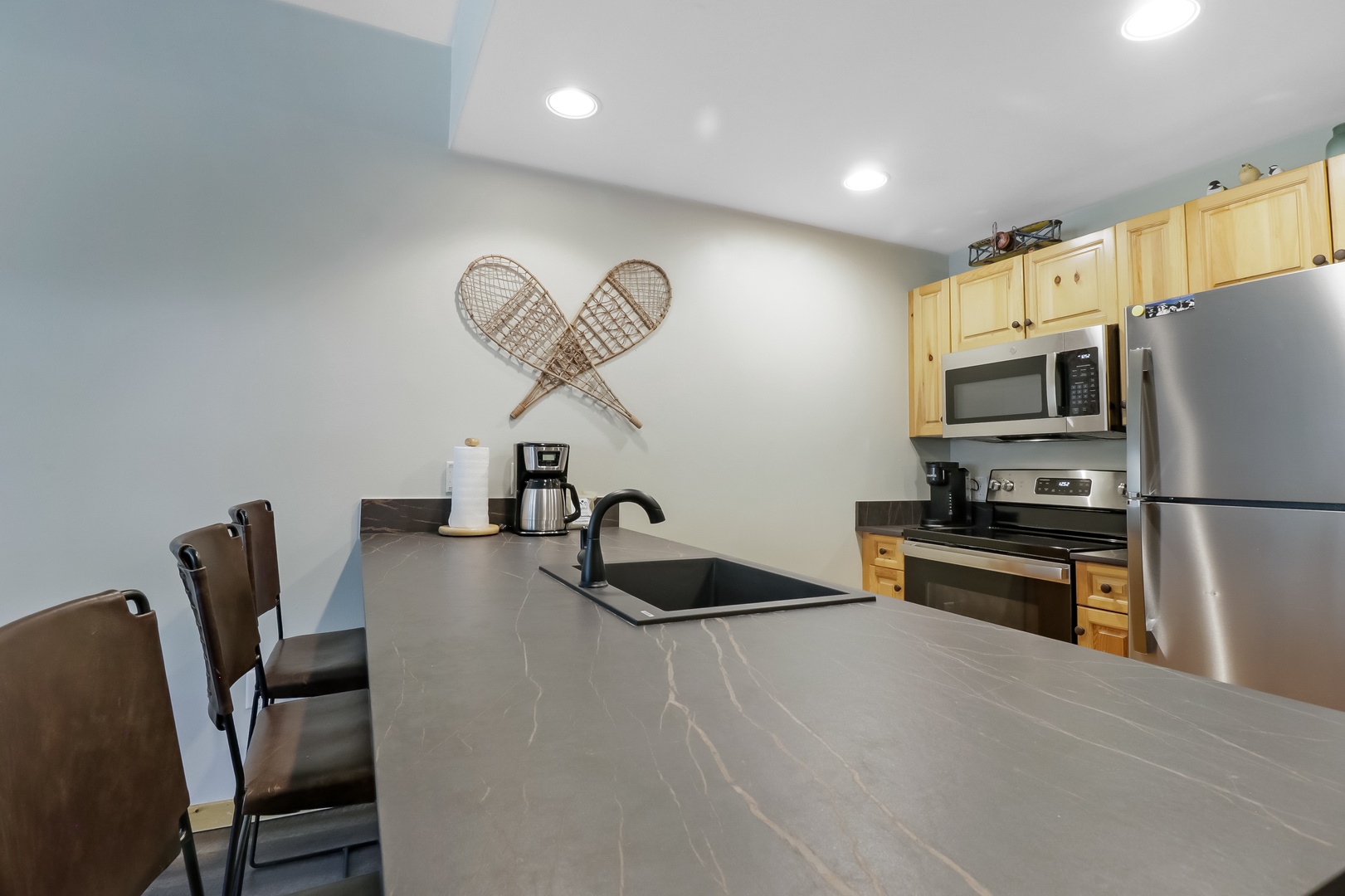 Your fully equipped kitchen invites you to prepare meals with ease, featuring modern stainless appliances, ample counter space, and charming alpine decor that brings a cozy mountain feel to your stay.