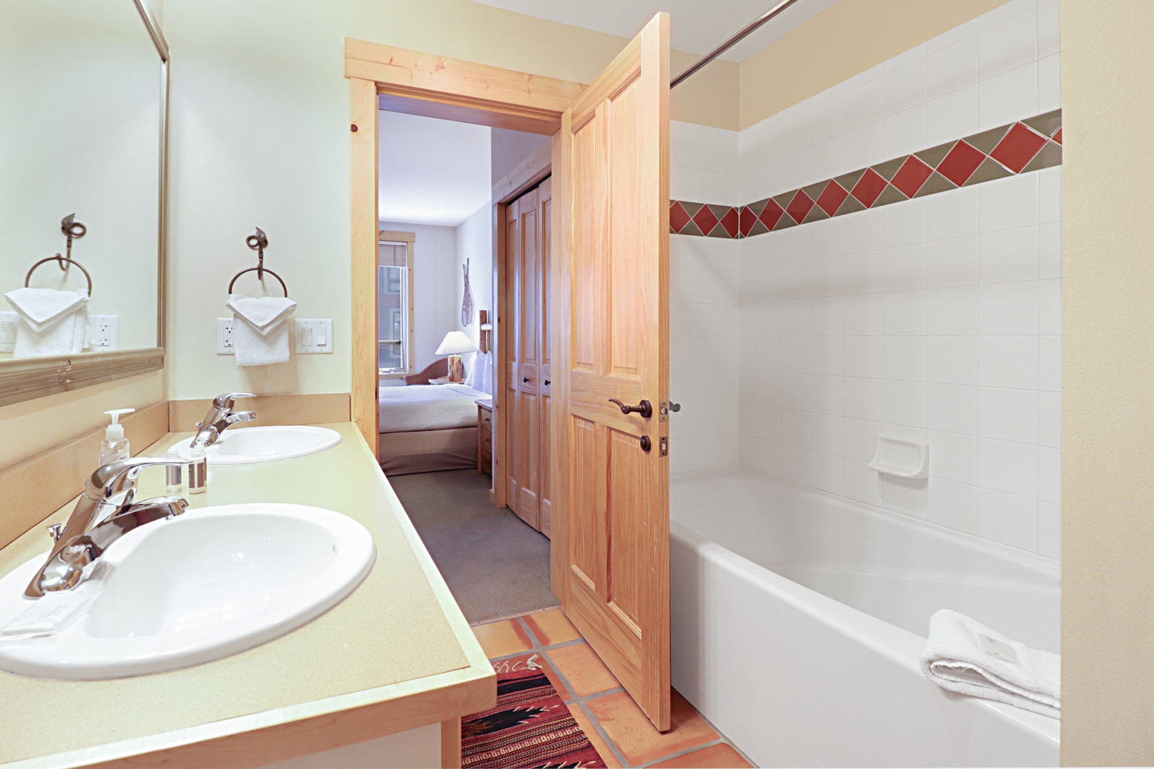 Refresh in your spacious bathroom with dual sinks and tub-shower combo, featuring charming tile accents and rustic touches.