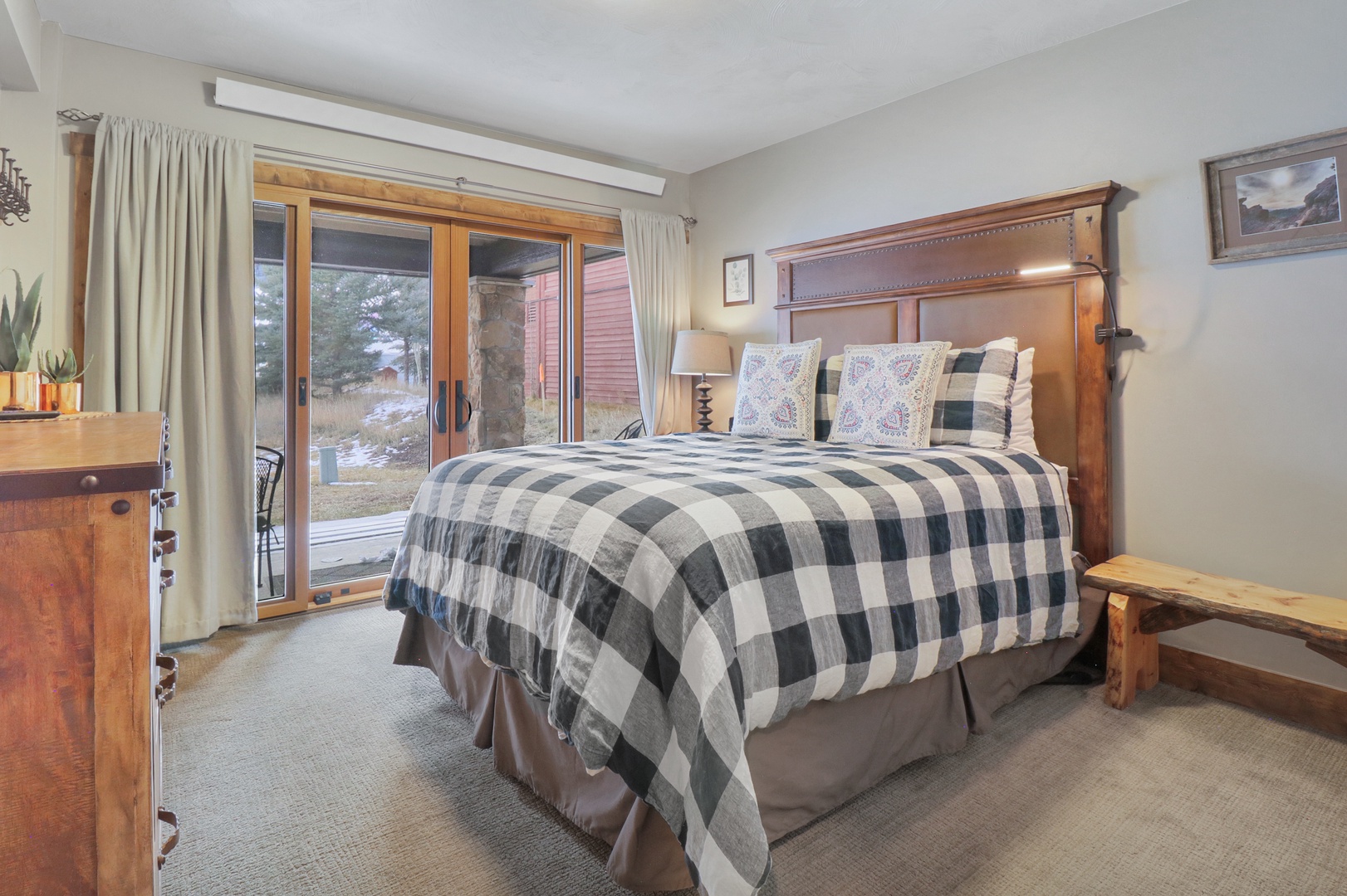 Sink into this cozy bedroom where rustic charm meets mountain comfort. You'll love the plaid bedding and warm wood furnishings that create the perfect retreat after your adventures.
