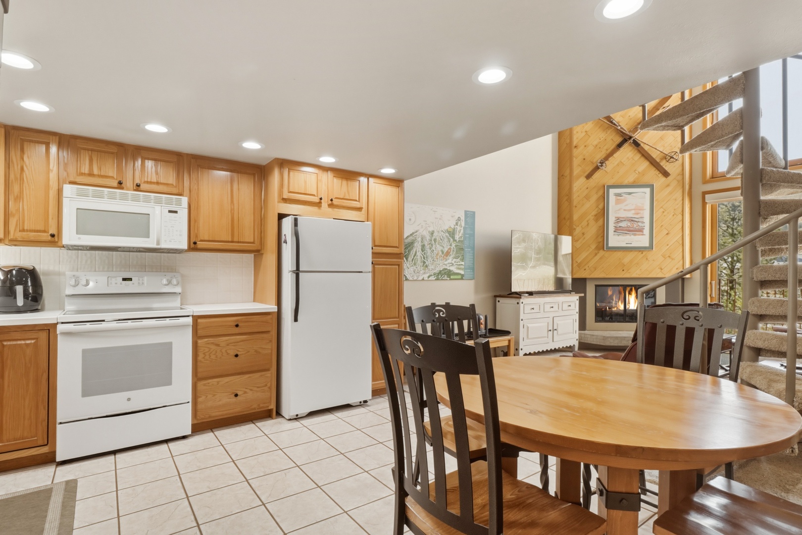 Your fully equipped kitchen features warm wood cabinets, modern appliances, and a cozy dining table where you can gather for home-cooked meals.