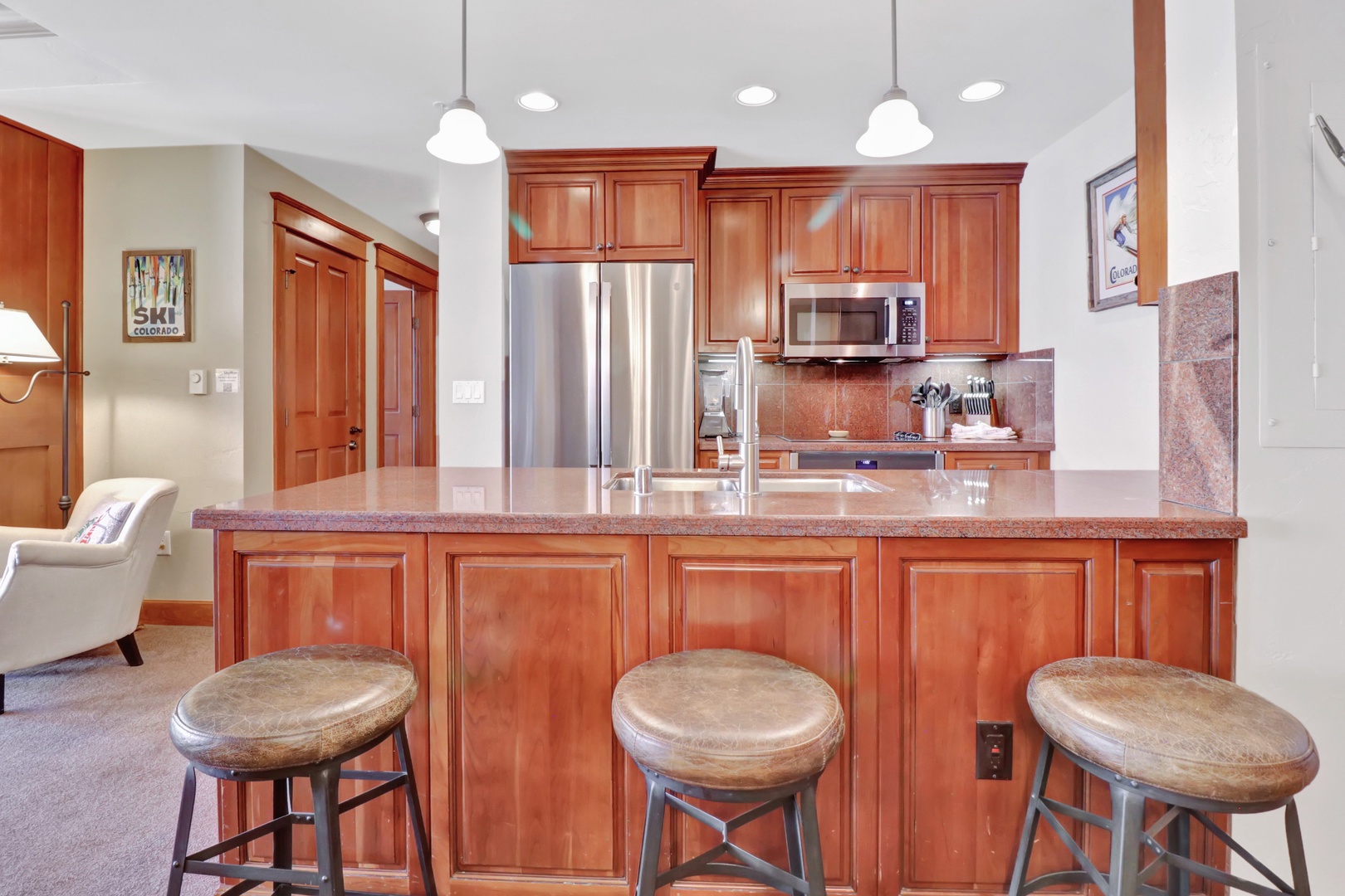 Your spacious kitchen features polished granite counters, rich wood cabinetry, stainless steel appliances, and bar seating—perfect for morning coffee or gathering after a day on the slopes.