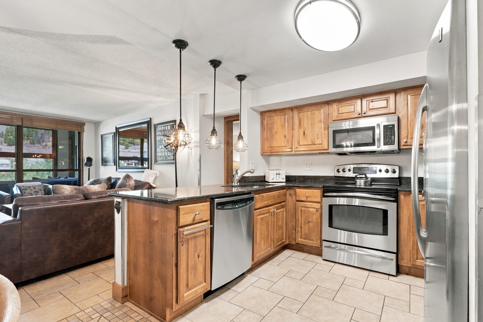 Your modern kitchen features stainless steel appliances, warm wood cabinetry, and granite countertops—ready for you to whip up meals with ease. Pendant lighting adds charm, while the open layout keeps you connected to the living space.