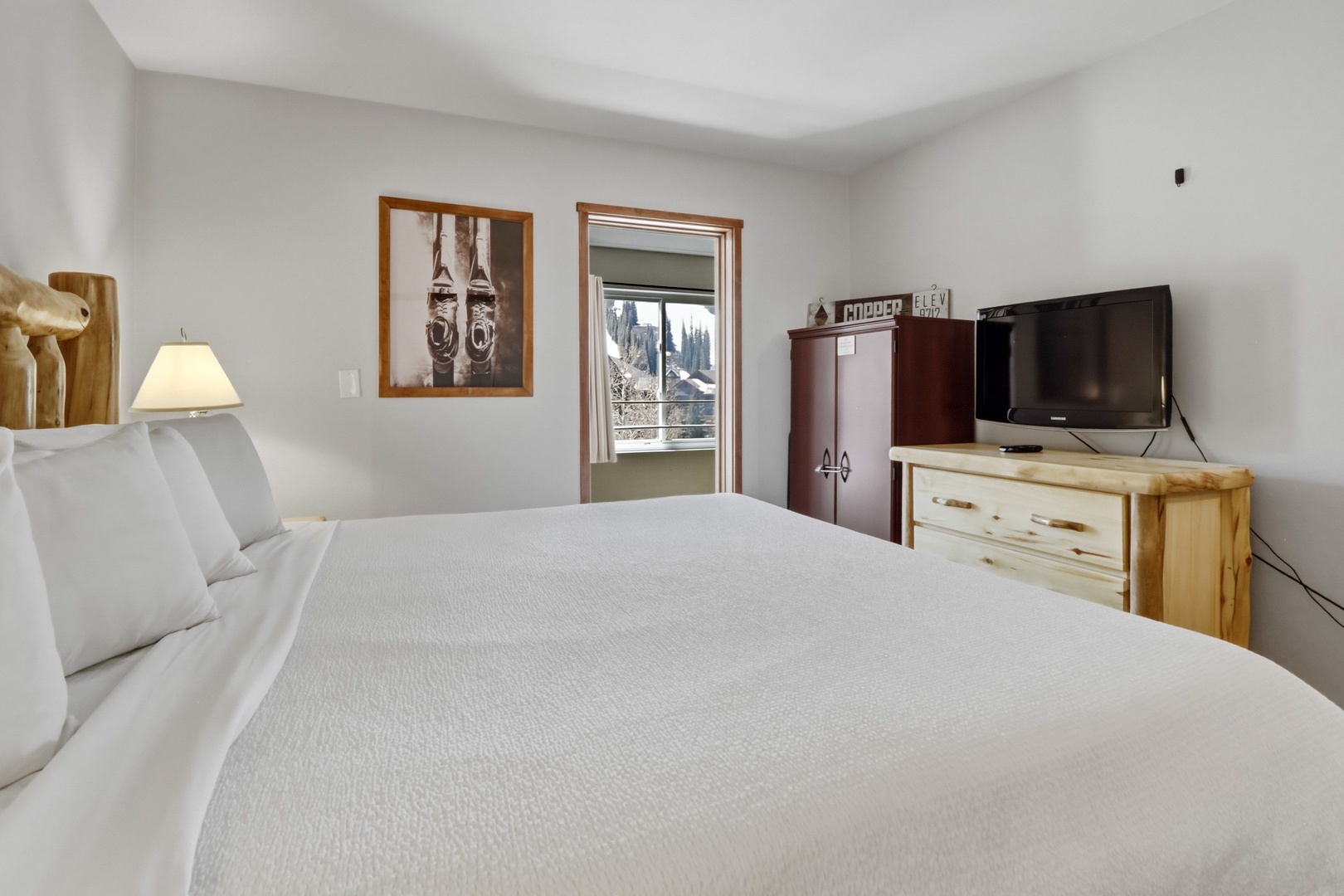 Sink into crisp white linens while enjoying mountain views through your private window. Rustic wood touches and modern TV create the perfect alpine retreat.
