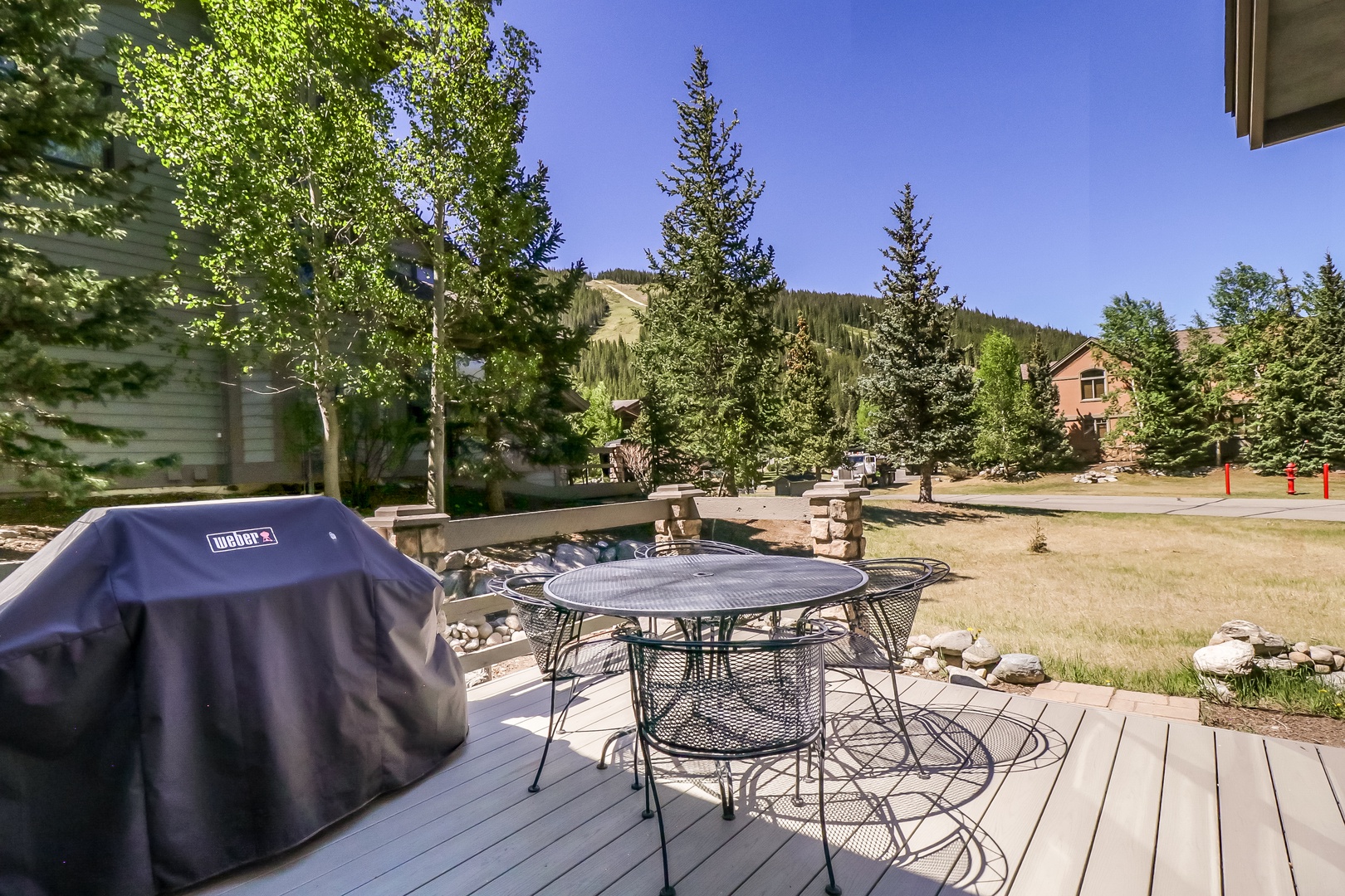 This mountain-view patio features outdoor dining and a Weber grill, perfect for savoring fresh air and scenic surroundings during your stay.