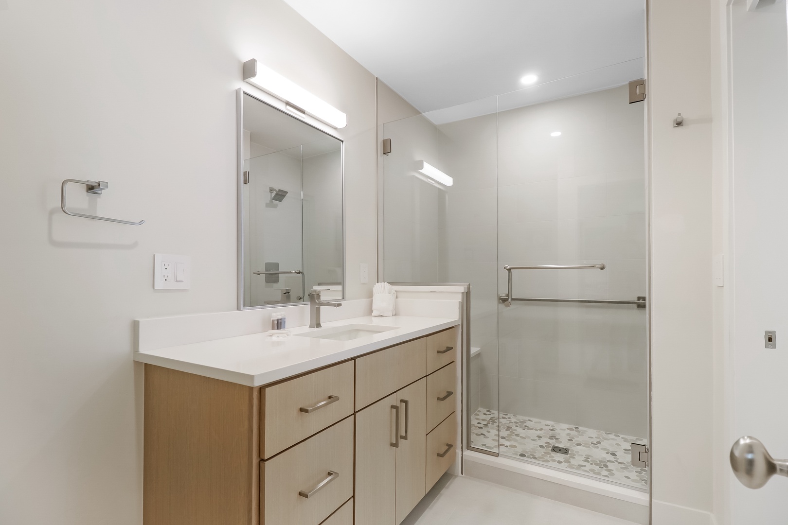 Step into your private spa-like bathroom with sleek modern finishes, a spacious walk-in shower, and crisp white surfaces that invite relaxation after a day of exploring.