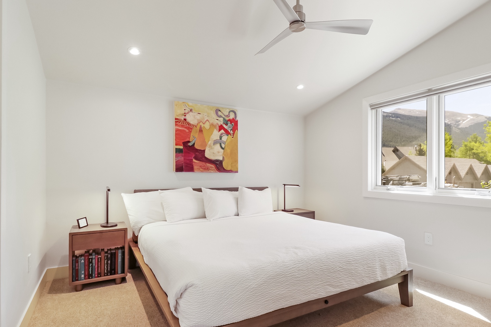 Drift off in your bright, serene bedroom with crisp white linens and stunning mountain views framing your peaceful retreat.
