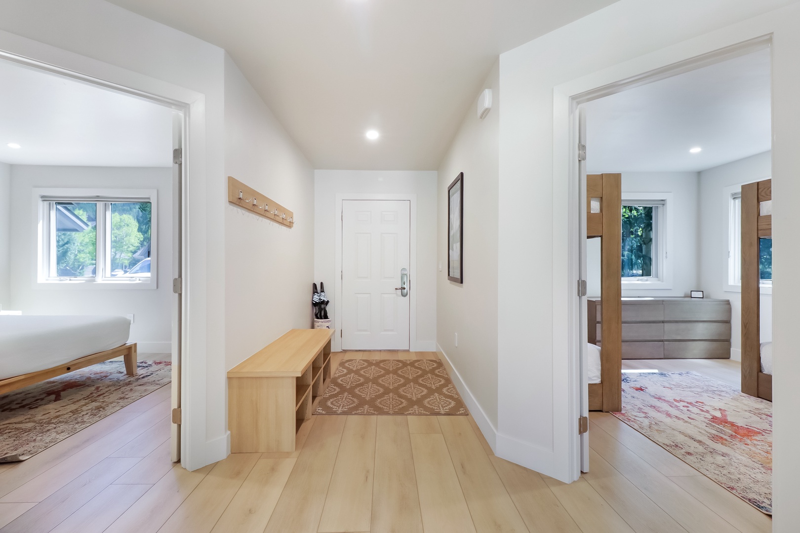 Step into your bright, welcoming entryway with warm wood accents and thoughtful touches. Two spacious bedrooms and a modern bathroom await on either side, ready for your arrival.