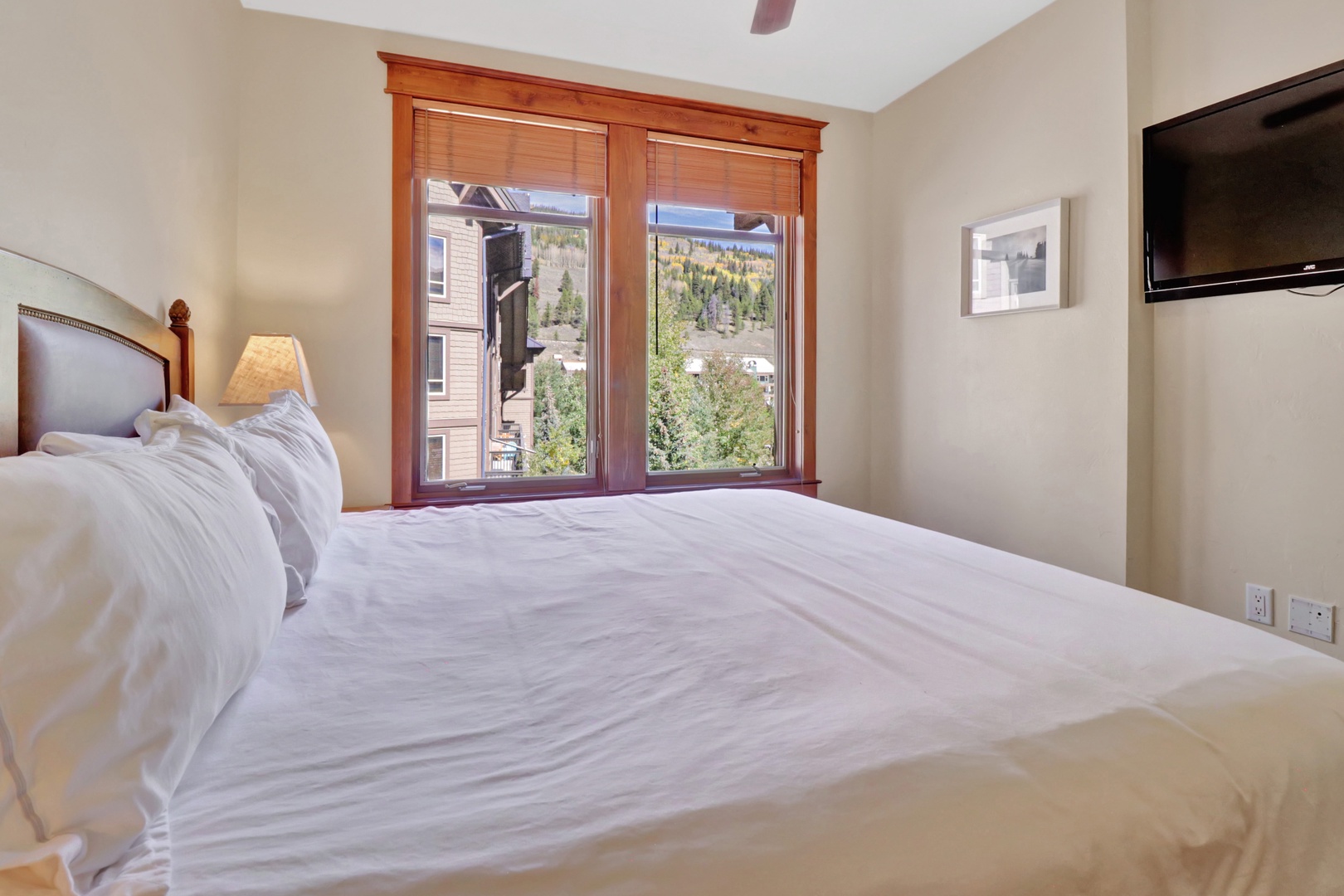 Sink into fresh linens and wake to mountain views framed by warm wood accents—your restful retreat awaits.