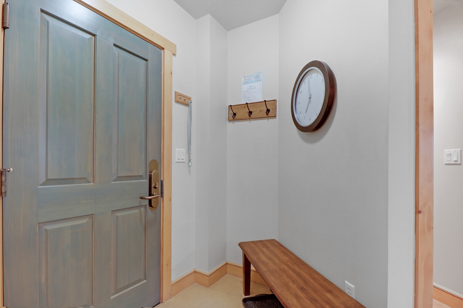 Your peaceful entry awaits, complete with a welcoming bench to settle in, hooks to hang your gear, and a classic clock keeping time on your adventures.