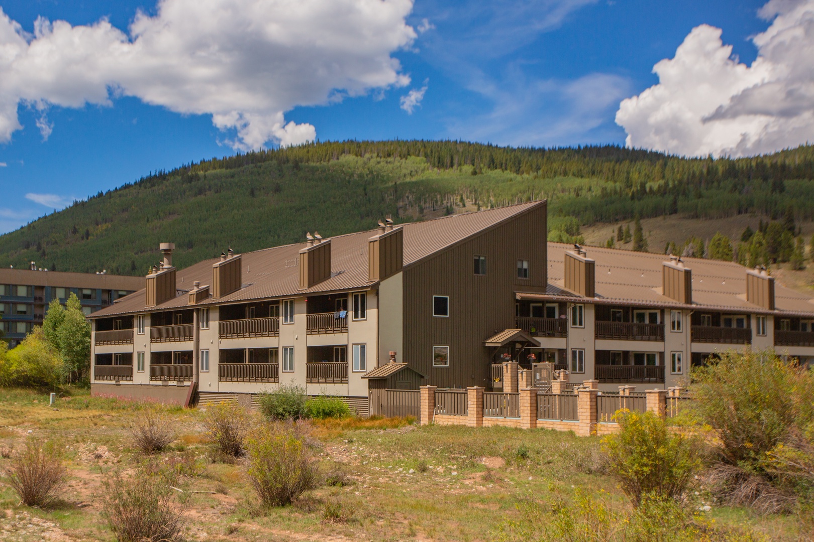 A multi-level vacation property nestled against forested mountain slopes, offering guests immediate access to outdoor adventure and scenic alpine surroundings.